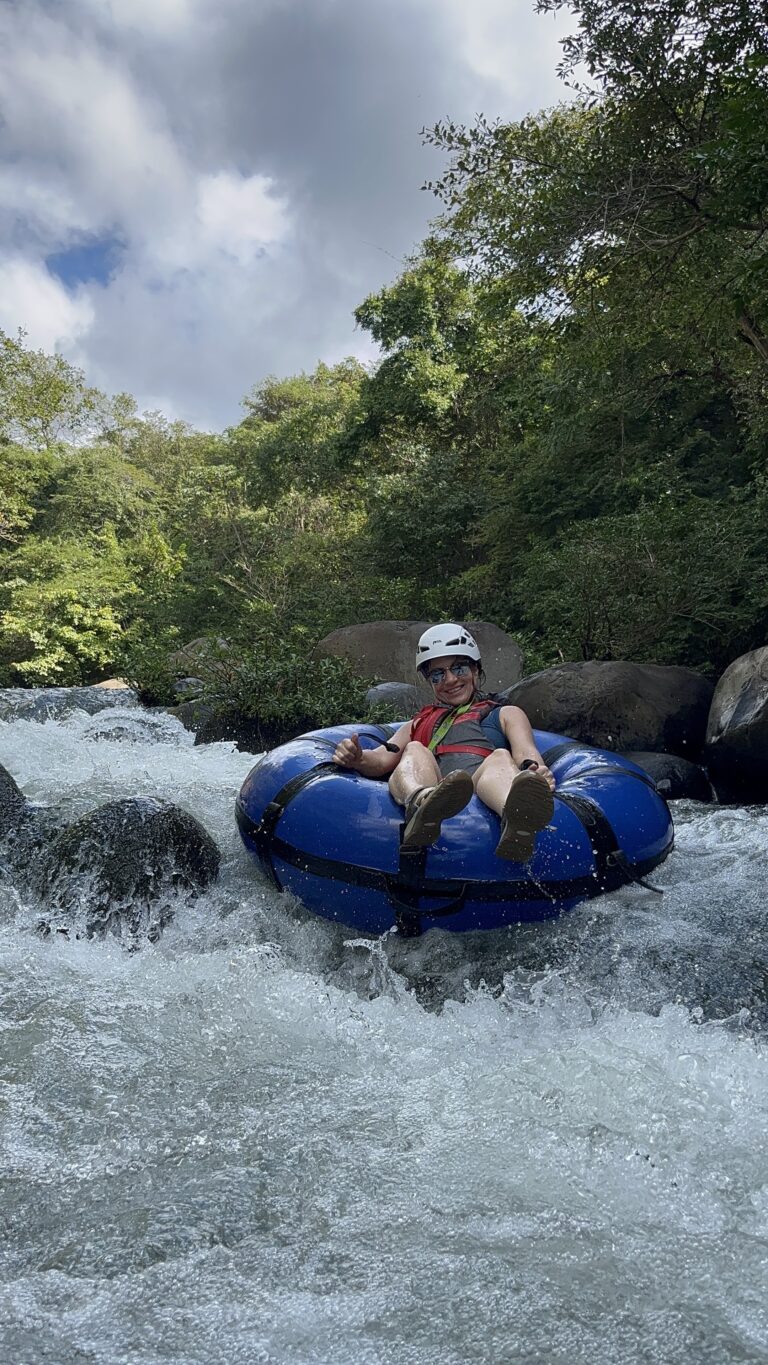 Group with helmets river tubing through a forested canyon in Guanacaste