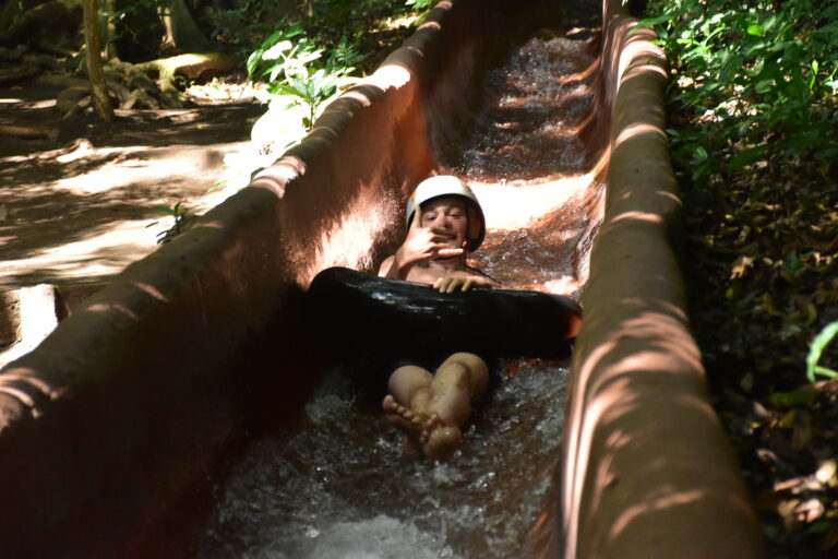 Guest riding an inner tube down a jungle water slide in Guanacaste