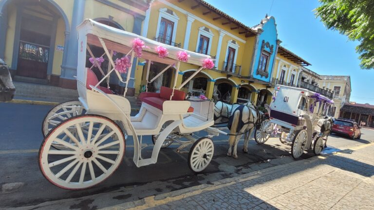 Horse-drawn carriage in front of a colonial church in Granada, Nicaragua