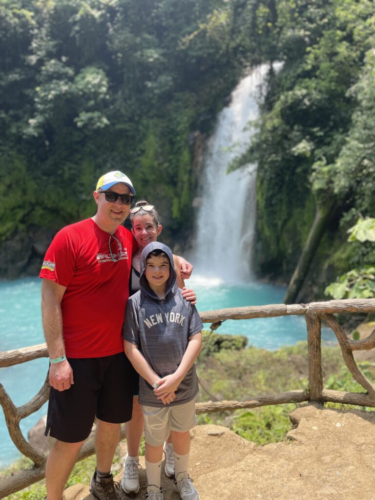 Smiling guest at the Río Celeste waterfall viewpoint in Tenorio